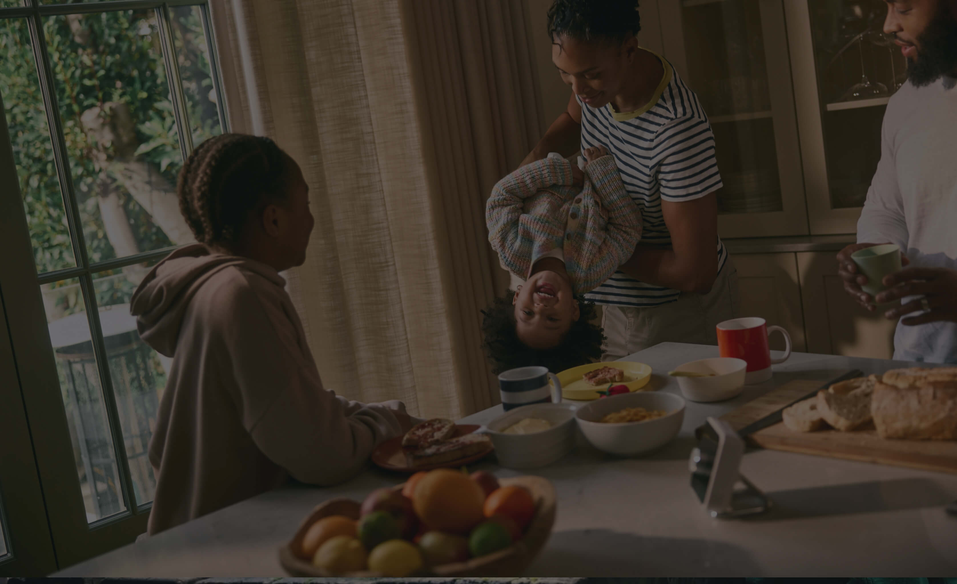 Hive Thermostat in the kitchen with a mother and child cooking